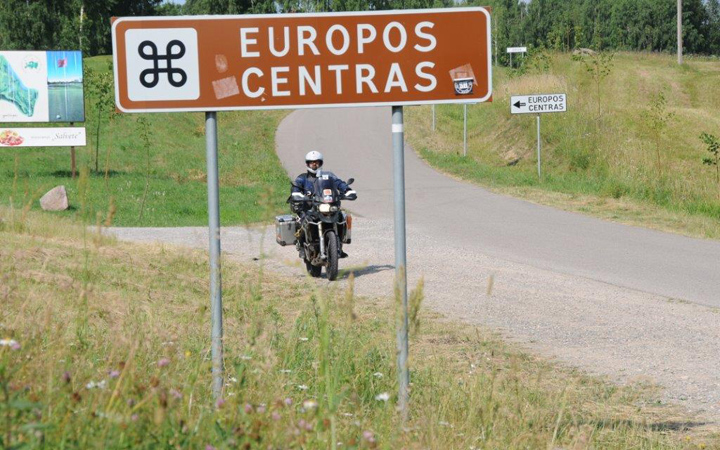 Ein Motorrad hinter einem Strassenschild mit der Aufschrift "Europos Centras" bei einer unserer Motorradreisen im Baltikum