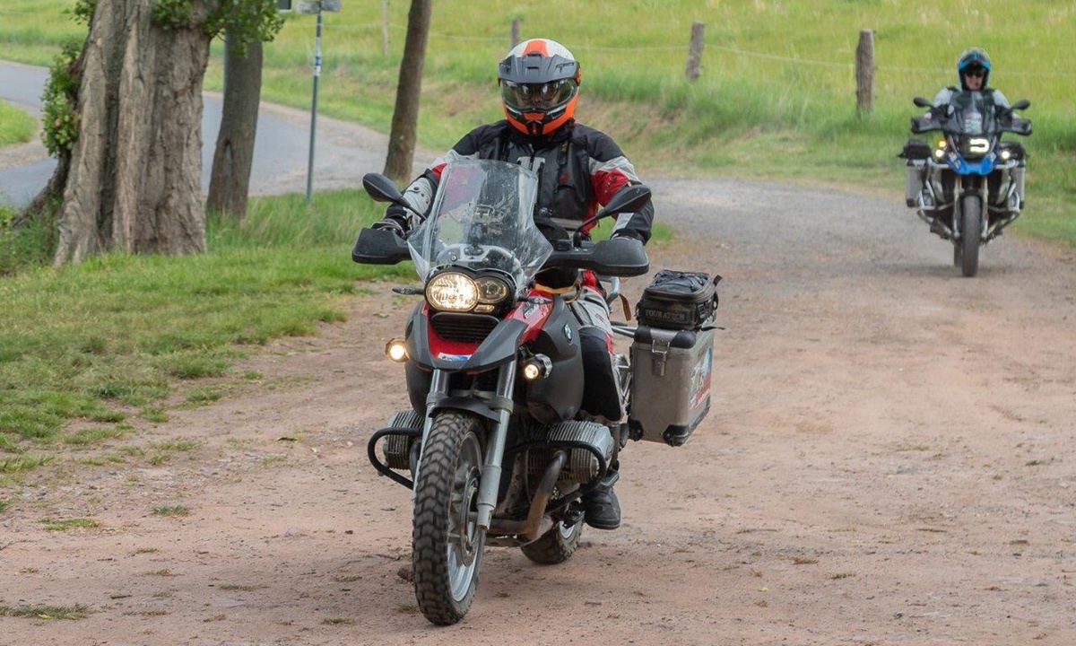Ein Motorradfahrer mit rotem Helm sitzt auf seinem Motorrrad des Herstellers BMW