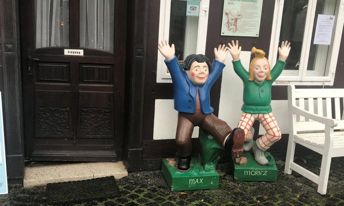 Skulpturen der Kinderbuchfiguren "Max" und "Moritz" vor einem Fachwerkhaus