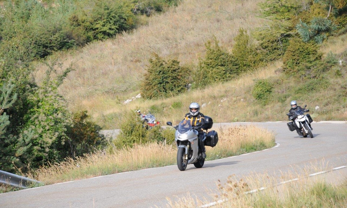 zwei Motorradfahrer auf der Kurve einer Bergstrasse