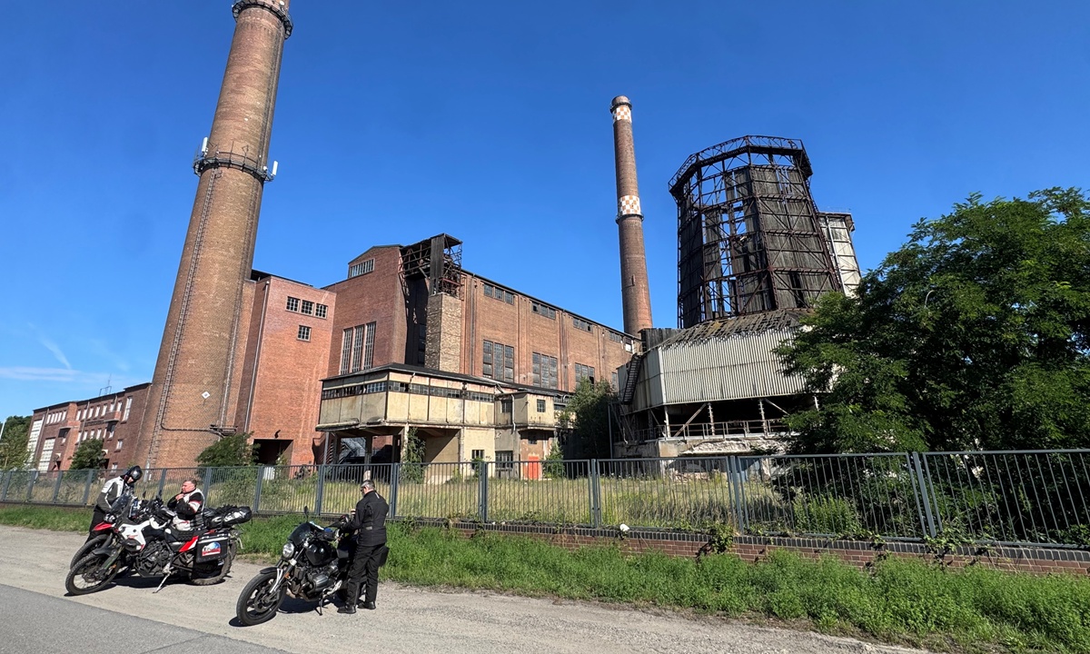 Motorraeder parken vor der Industrieruine eines ehemaligen Kraftwerks