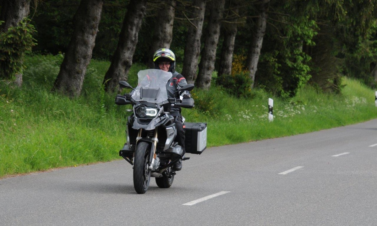 zufriedene Motorradfahrerin auf ihrer Maschine bei unserer "Kurvenfieber Roehn" Mottour