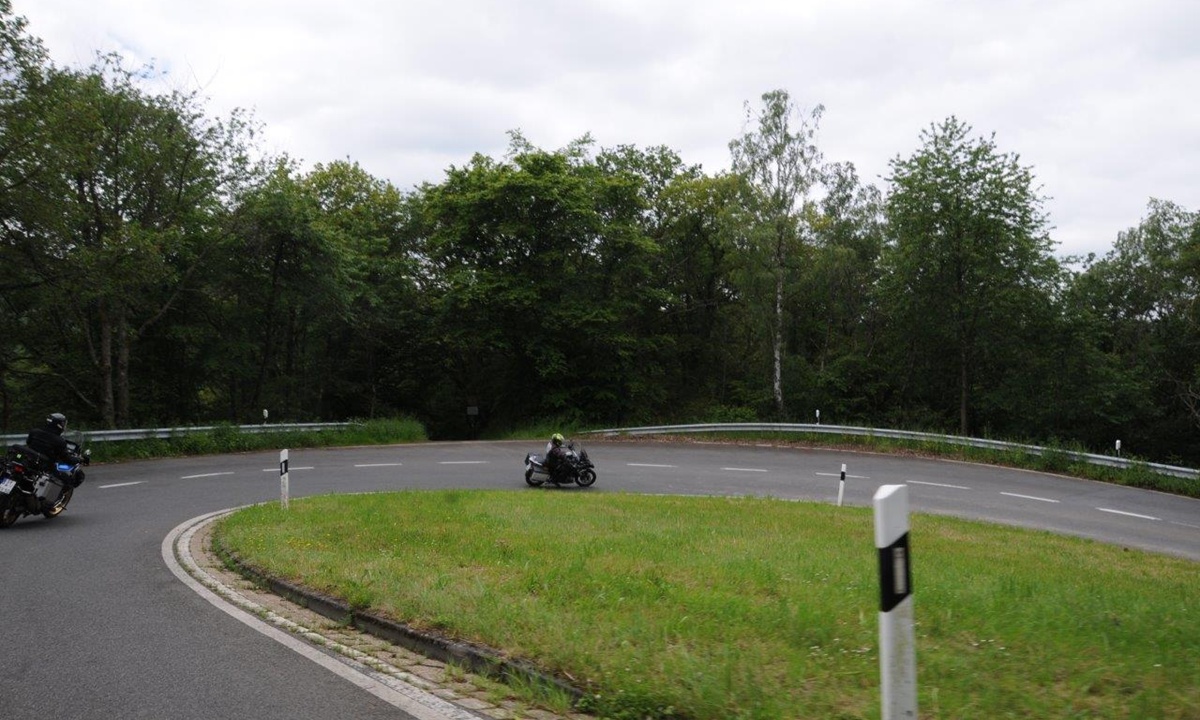 zwei Motorraeder durchfahren die enge Kurve einer Landstrasse