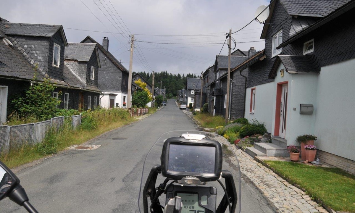 POV-Aufnahme eines Motorradfahrers beim Durchfahren einer Wohnsiedlung