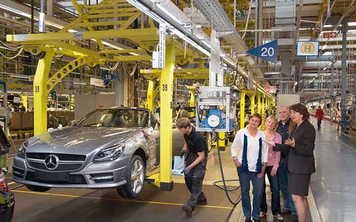 Eine Tourgruppe beobachtet die Herstellung eines Mercedes-Carbios bei einer Werksfuehrung bei Mercedes Benz