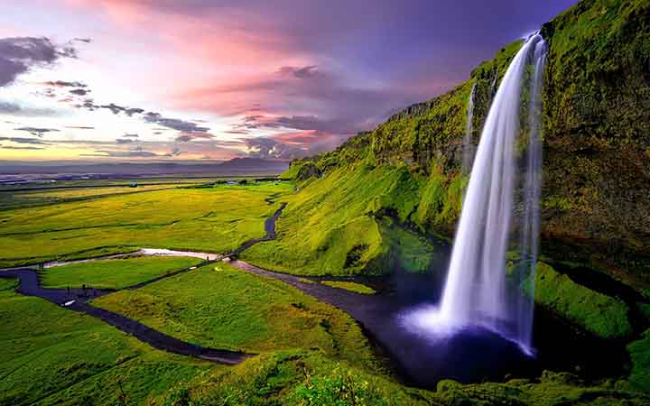 Seljalandfoss-Wasserfall in der gruenen Mooslandschaft von Island